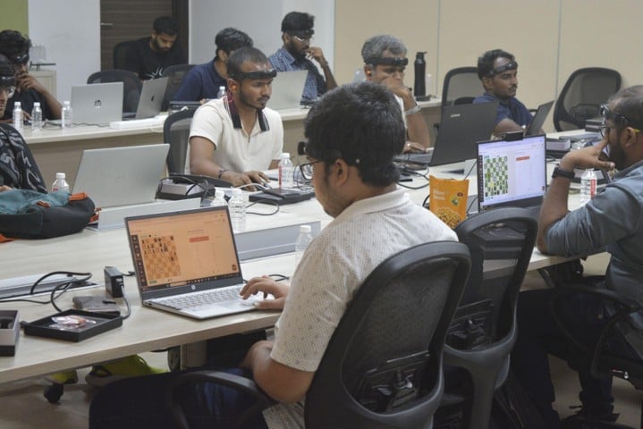 Chess players wearing Neurostellar's Orbit cognitive-tracking headsets while competing on laptops
